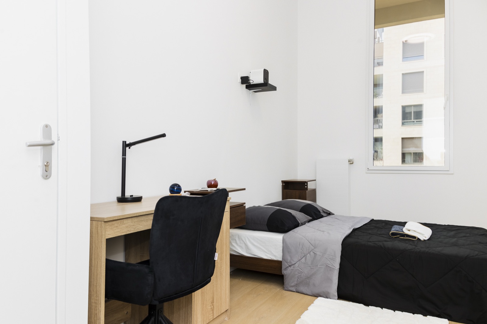 Chambre meublée avec lit, bureau et fenêtre